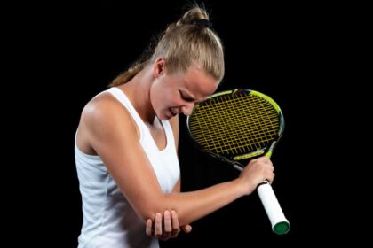 A female tennis player holding her elbow because of tennis elbow pain