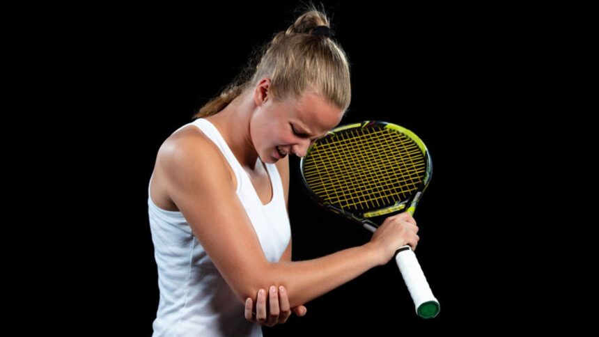 A female tennis player holding her elbow because of tennis elbow pain