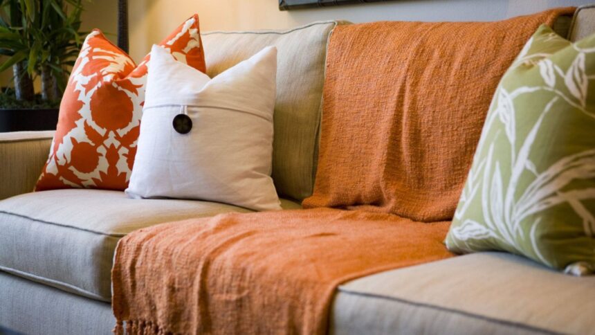 A beatiful sofa with cosy blankets and pillows on it